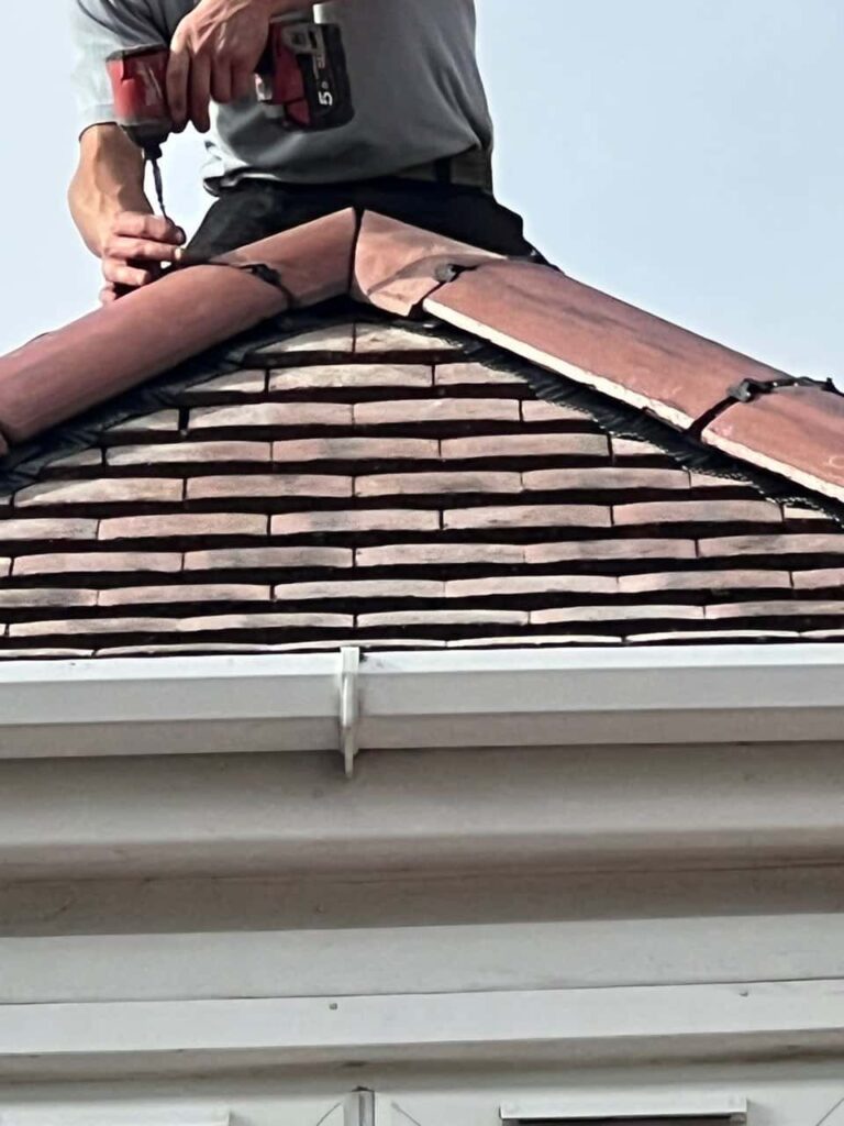 This is a photo of one of the operatives of Ravenshead Roofing Repairs installing new ridge tiles