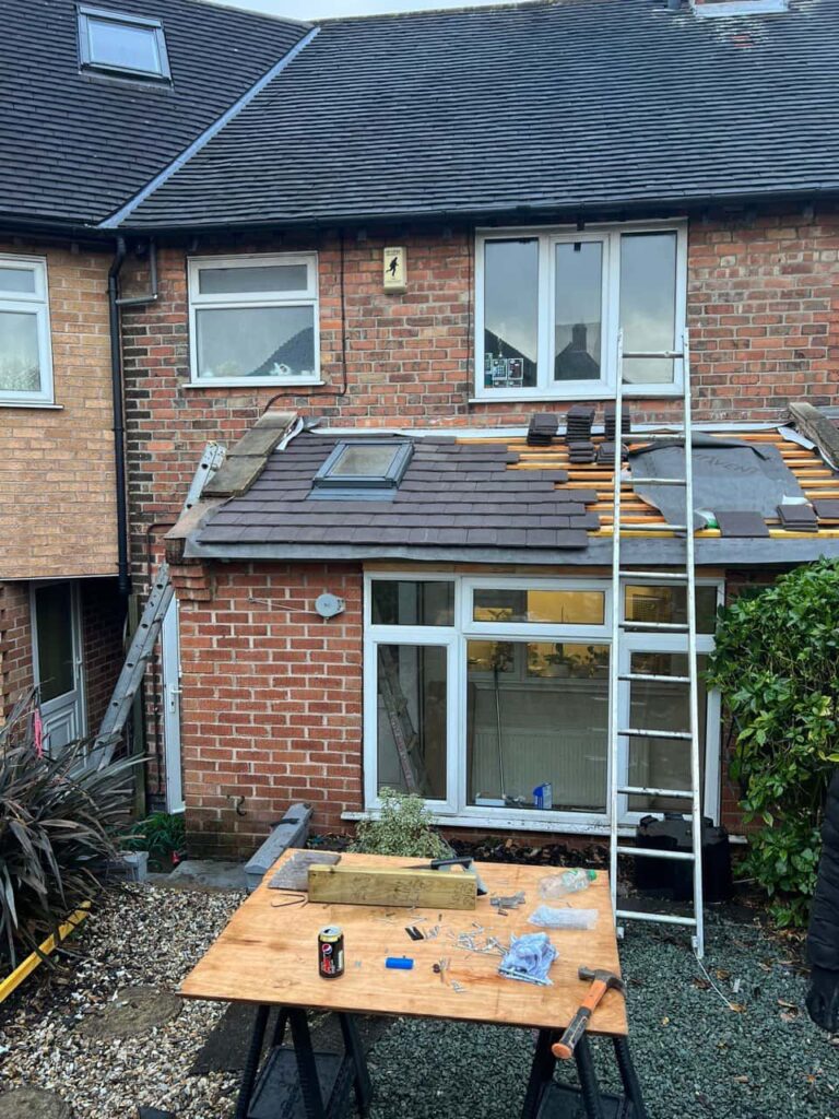 This is a photo of a roof extension that is having new roof tiles installed. This is a photo taken from the roof ridge looking down a tiled pitched roof on to a flat roof. Works carried out by Ravenshead Roofing Repairs